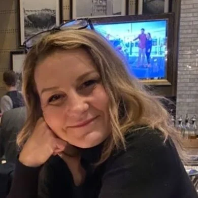 Laura Leipert smiling, her chin resting on her hand