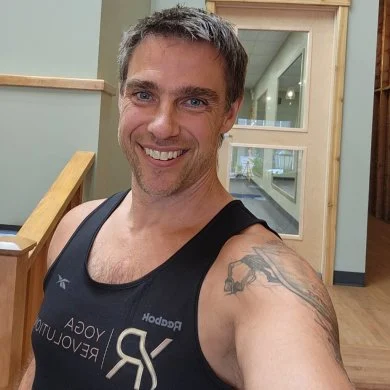 Mike Reid smiling in a black YogaRevolution tank top